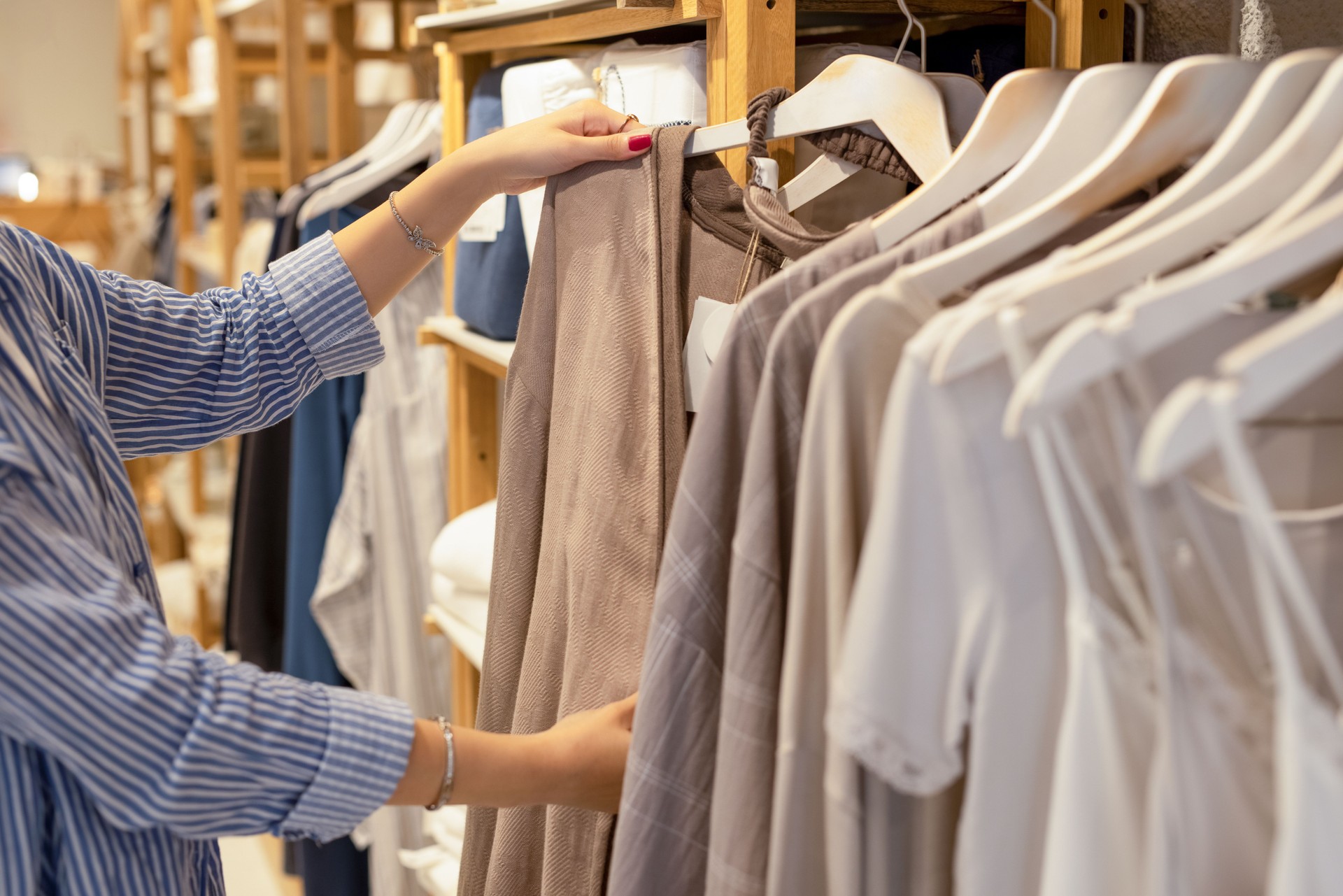 Female hand taking a clothes out at clothing store